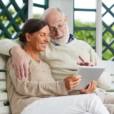 Een oudere man en vrouw die naar een tablet kijken Een oudere man en vrouw die naar een tablet kijken