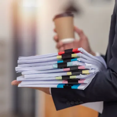 Iemand die een stapel papieren vasthoudt Iemand die een stapel papieren vasthoudt